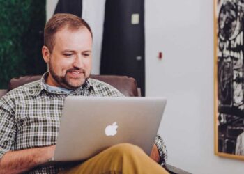 Hombre revisando su cuenta corriente online en una Mac ecommerce