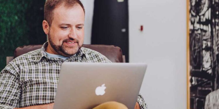 Hombre revisando su cuenta corriente online en una Mac ecommerce