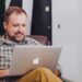 Hombre revisando su cuenta corriente online en una Mac ecommerce
