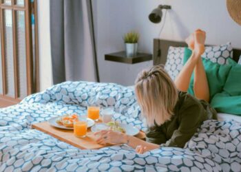 mujer acostada en la cama con desayuno