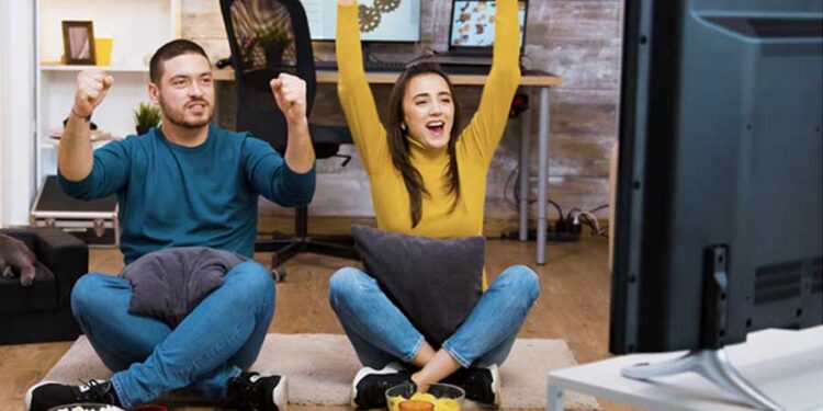 hombre y mujer en casa celebrando viendo la tv fútbol