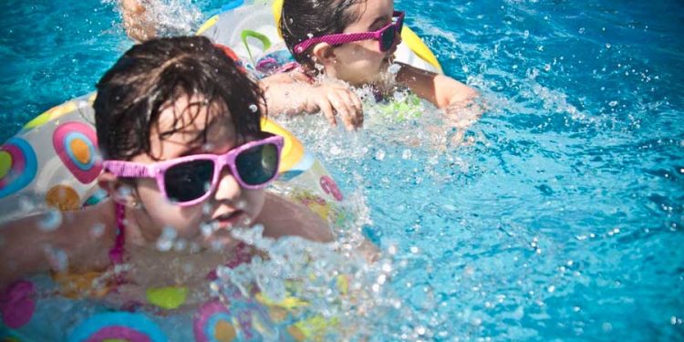 2 niñas en natación en una piscina inflable