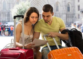 cyber wow hombre y mujer organizando viaje turismo con maletas turistas