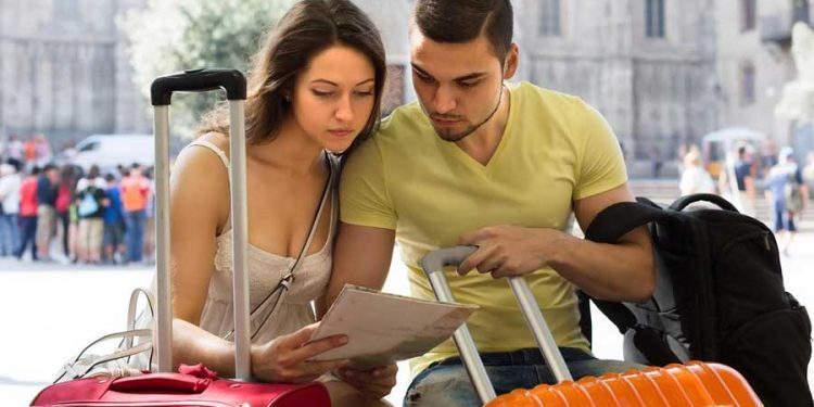 cyber wow hombre y mujer organizando viaje turismo con maletas turistas
