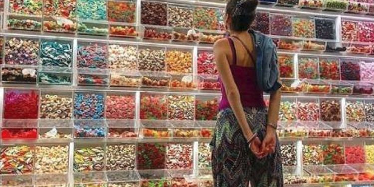 mujer viendo caramelos surtidos retail