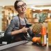 Feliz mujer cajera escaneando artículos de supermercado