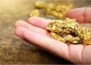 mano sosteniendo oro en mineral