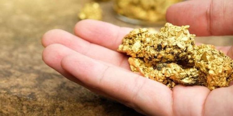 mano sosteniendo oro en mineral