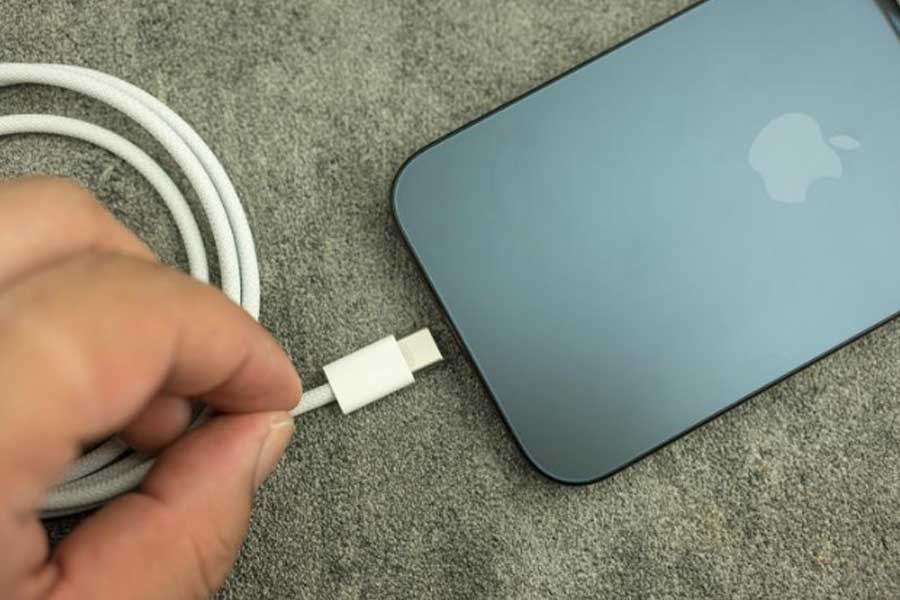 iPhone 15 con cable cargador USB