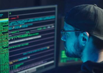 analista de sistemas programando y revisando amenazas cibernéticas y aplicando ciberseguridad
