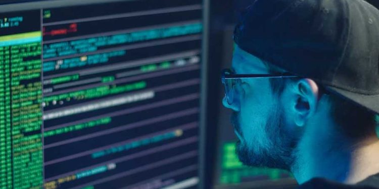 analista de sistemas programando y revisando amenazas cibernéticas y aplicando ciberseguridad