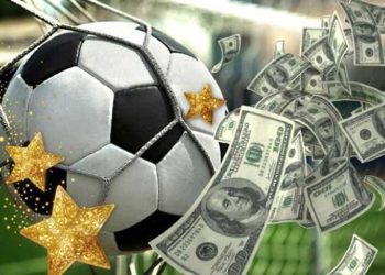 Balón de fútbol junto a muchos billetes de dólares