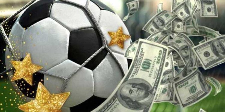 Balón de fútbol junto a muchos billetes de dólares