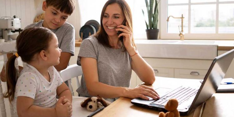 Día de la Madre mamá trabajando mientras cuida a sus hijos