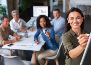 mujer talento con equipo de trabajo en reunión dando una presentación