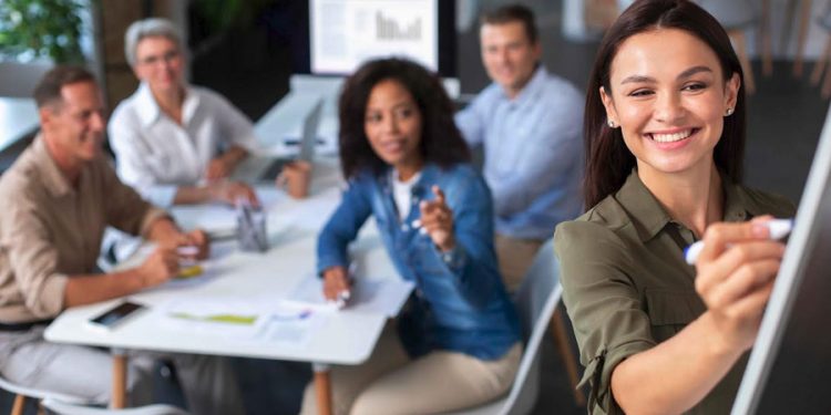 mujer talento con equipo de trabajo en reunión dando una presentación