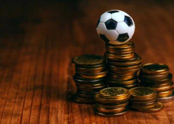 pelota de fútbol de juguete sobre unas monedas