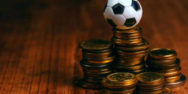 pelota de fútbol de juguete sobre unas monedas
