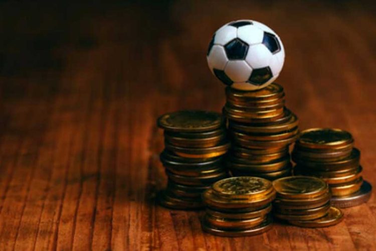 pelota de fútbol de juguete sobre unas monedas
