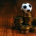 pelota de fútbol de juguete sobre unas monedas
