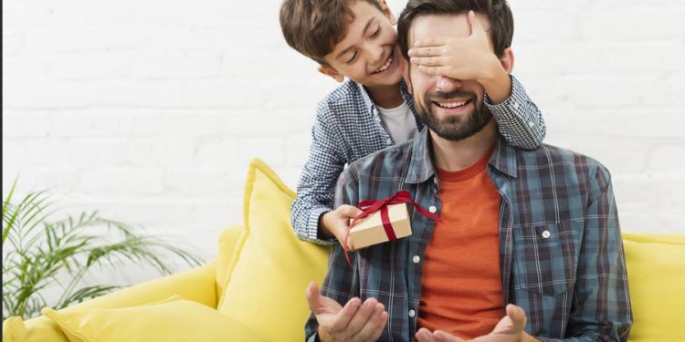 Dia del Padre hijo entregando regalo a papá