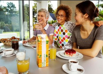 Familia de mujeres desayunando con bebidas