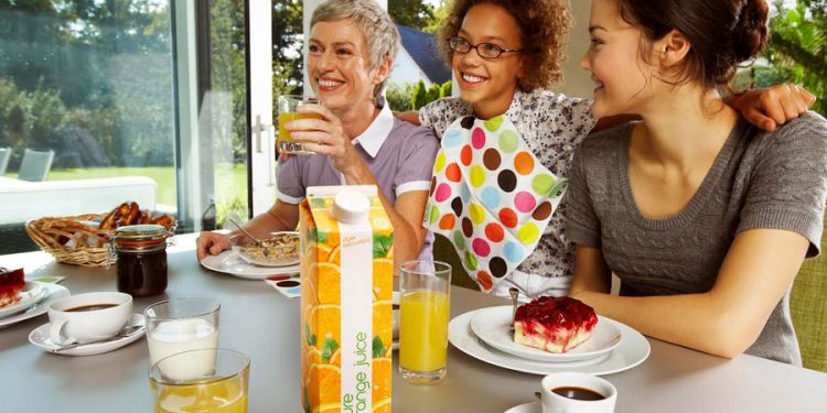 Familia de mujeres desayunando con bebidas