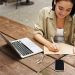 joven mujer trabaja o estudia en linea con una laptop