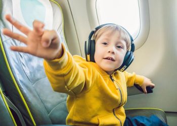 niño viajando en avión con auriculares