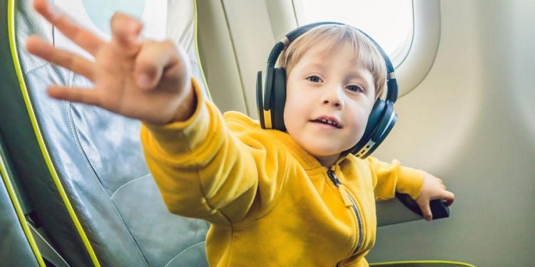 niño viajando en avión con auriculares