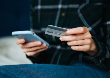 Hombre compra online con tarjeta de credito con smartphone
