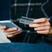 Hombre compra online con tarjeta de credito con smartphone