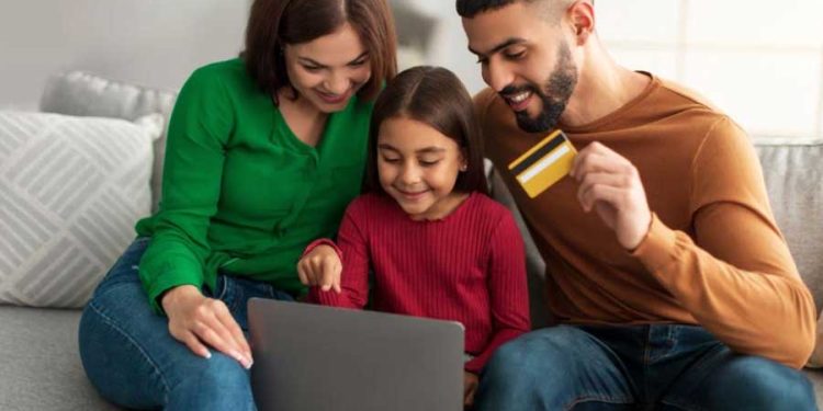 Niña comprando online con los padres ecommerce