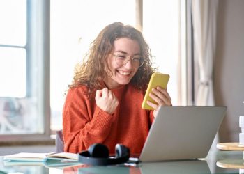 mujer feliz con el móvil en la mano comprando online