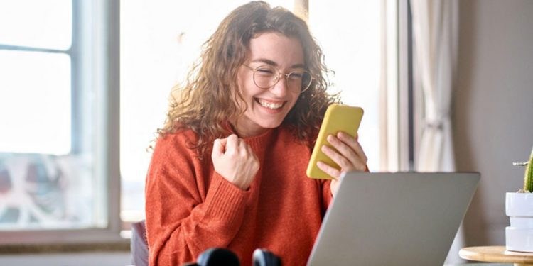 mujer feliz con el móvil en la mano comprando online
