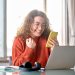 mujer feliz con el móvil en la mano comprando online