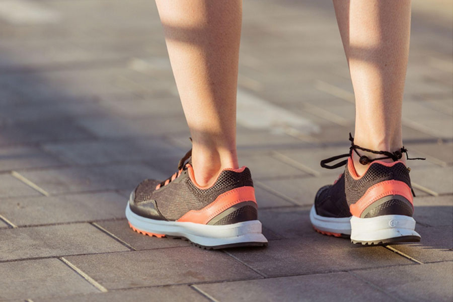 freepik-joven-usando-zapatillas-deportivas-negras con rayas rojas
