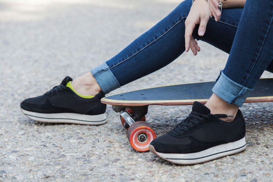 freepik-mujer-usando-zapatillas-deportivas-negras en jean