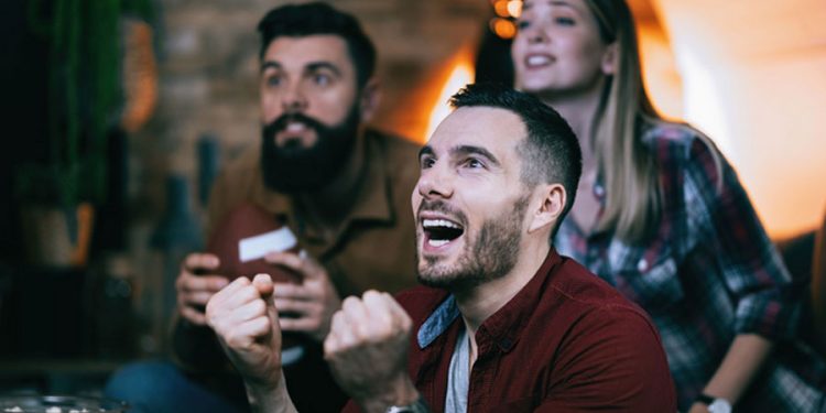 Grupo de personas mirando un partido de futbol